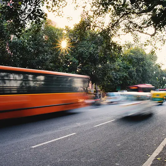 sun bus moving car traffic delhi